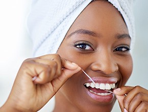 Closeup of woman smiling while flossing