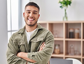 Man in green jacket smiling in home office