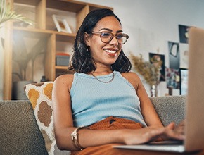 Woman smiling while working on laptop at home
