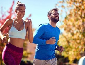 man and woman jogging together outdoors