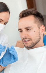 a woman holding her cheeks due to a dental emergency