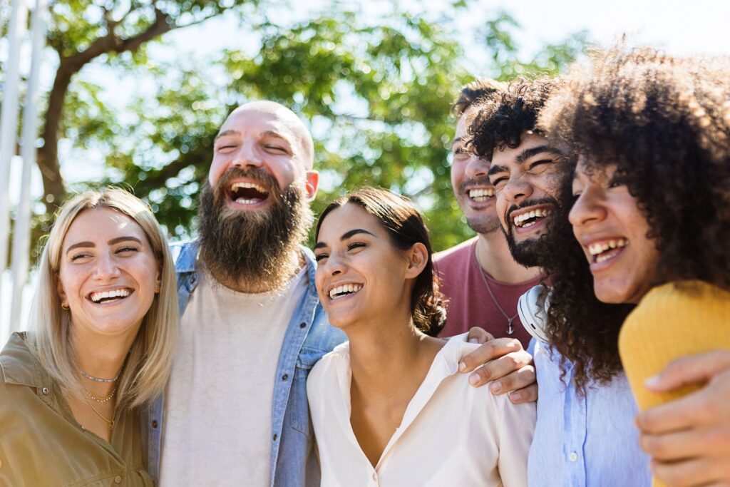 Diverse group of people outside smiling together